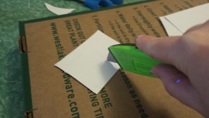 Cutting stencils from thin cardboard.